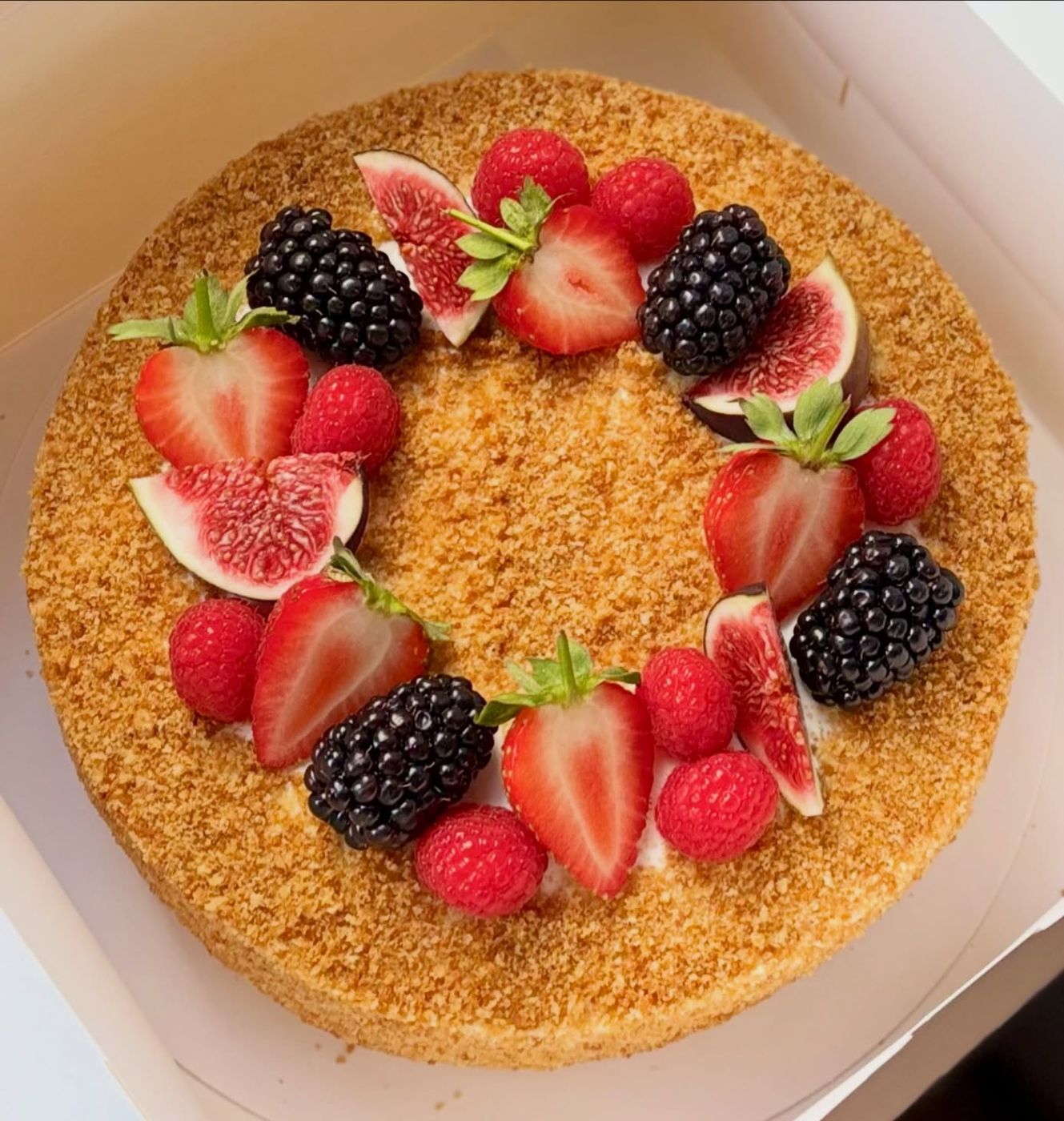 A homemade Ukrainian honey cake topped with figs and berries